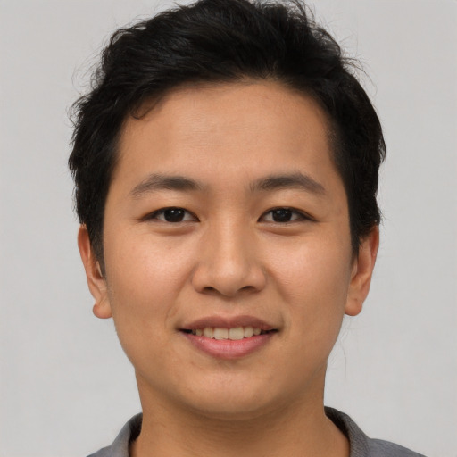 Joyful asian young-adult male with short  brown hair and brown eyes