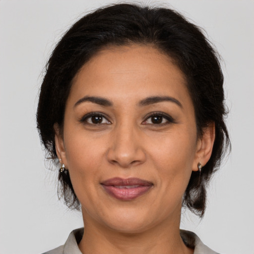 Joyful latino adult female with medium  brown hair and brown eyes