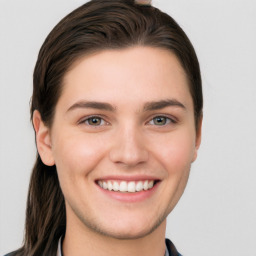Joyful white young-adult female with long  brown hair and grey eyes