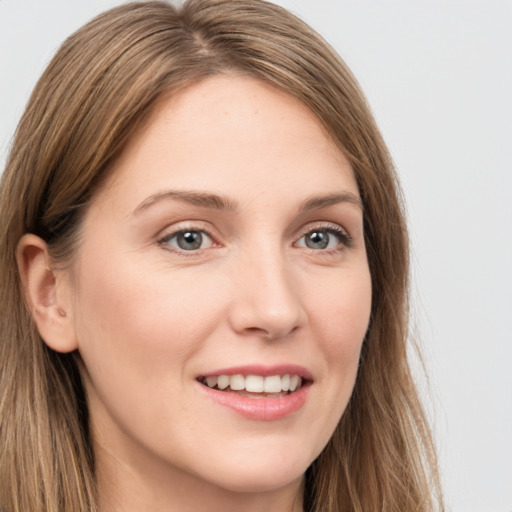 Joyful white young-adult female with long  brown hair and grey eyes