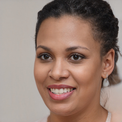 Joyful black young-adult female with short  brown hair and brown eyes