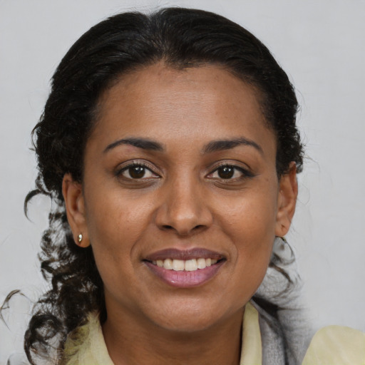 Joyful black young-adult female with medium  brown hair and brown eyes