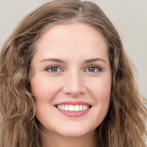 Joyful white young-adult female with long  brown hair and green eyes