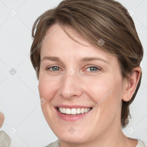 Joyful white young-adult female with medium  brown hair and grey eyes