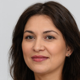 Joyful white adult female with long  brown hair and brown eyes