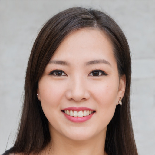 Joyful asian young-adult female with long  brown hair and brown eyes