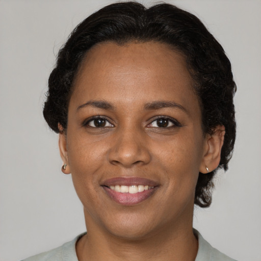 Joyful black young-adult female with short  brown hair and brown eyes