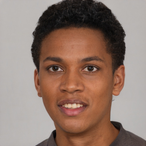 Joyful black young-adult male with short  brown hair and brown eyes