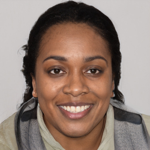 Joyful black adult female with long  brown hair and brown eyes