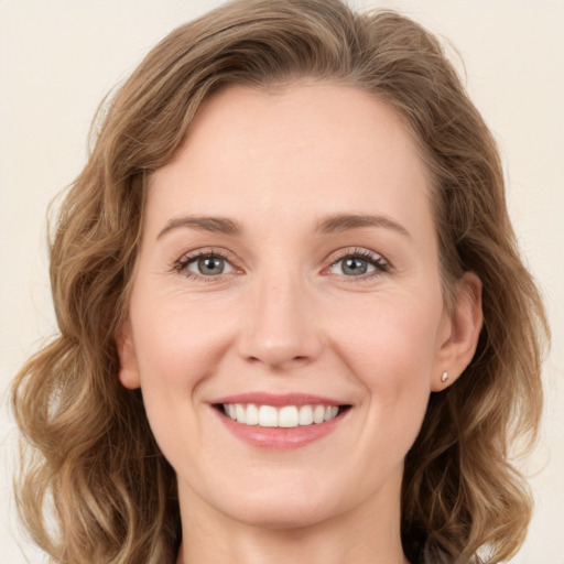 Joyful white young-adult female with medium  brown hair and green eyes