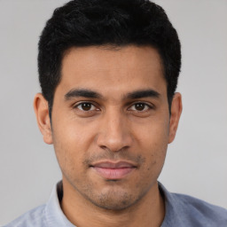 Joyful latino young-adult male with short  black hair and brown eyes