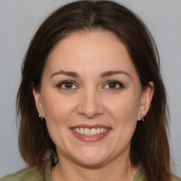 Joyful white adult female with medium  brown hair and brown eyes