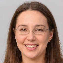 Joyful white adult female with long  brown hair and grey eyes