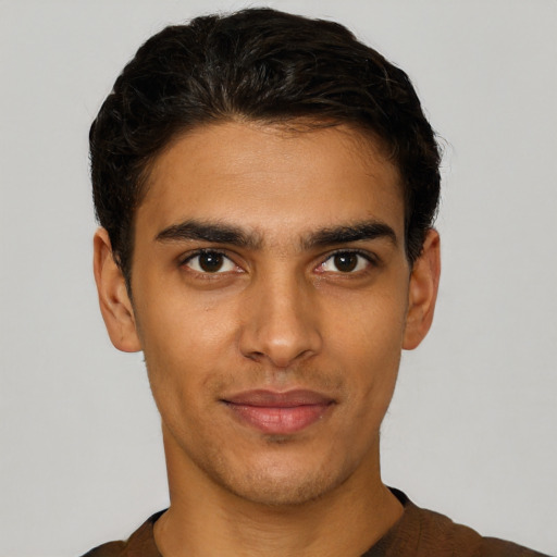 Joyful latino young-adult male with short  brown hair and brown eyes