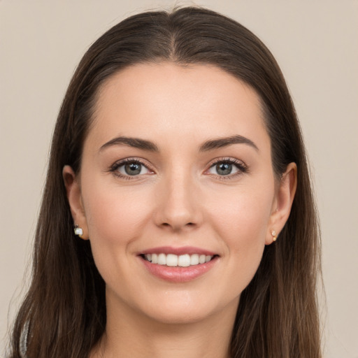 Joyful white young-adult female with long  brown hair and brown eyes