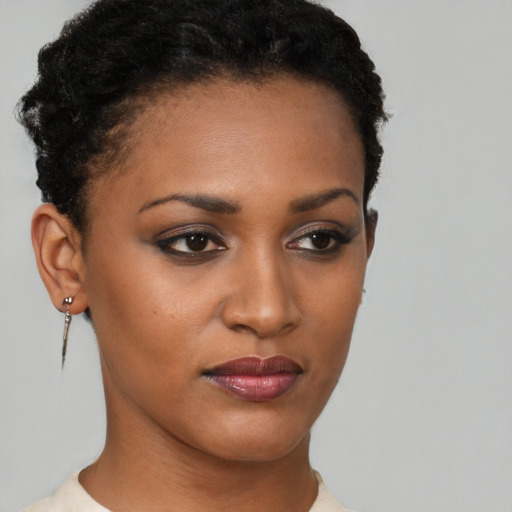 Joyful black young-adult female with short  black hair and brown eyes