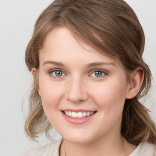 Joyful white young-adult female with medium  brown hair and grey eyes