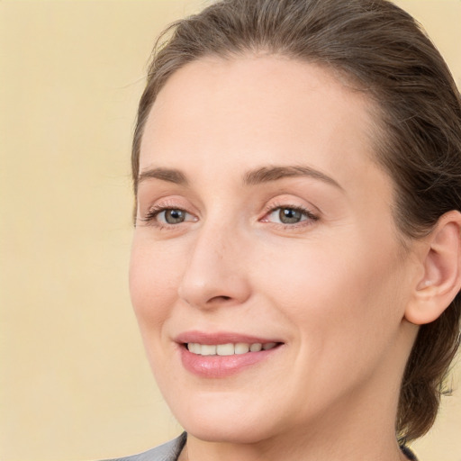 Joyful white young-adult female with medium  brown hair and grey eyes