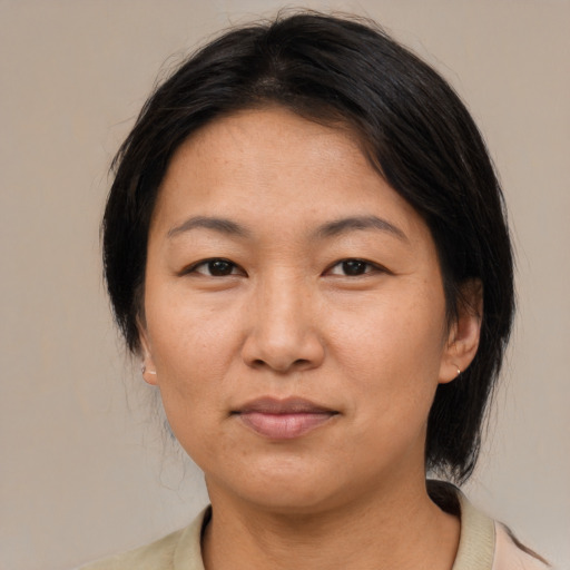 Joyful asian adult female with medium  brown hair and brown eyes