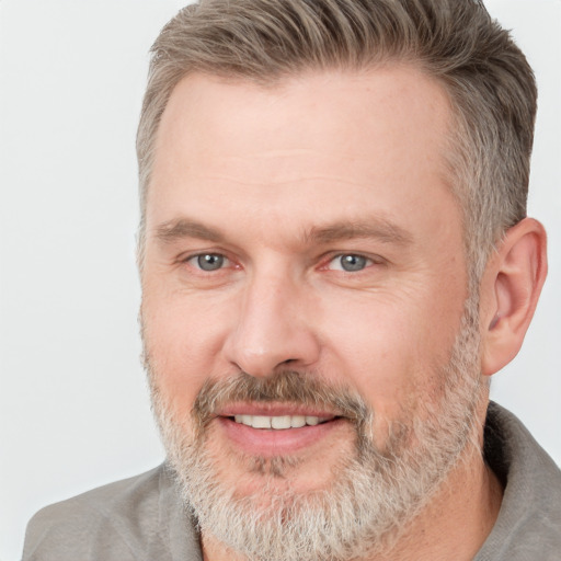 Joyful white adult male with short  brown hair and grey eyes