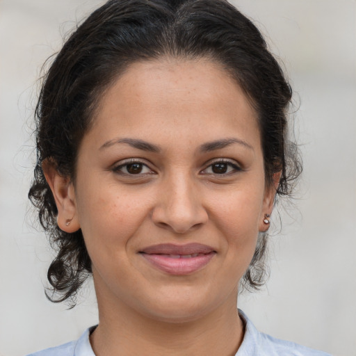 Joyful latino young-adult female with medium  brown hair and brown eyes