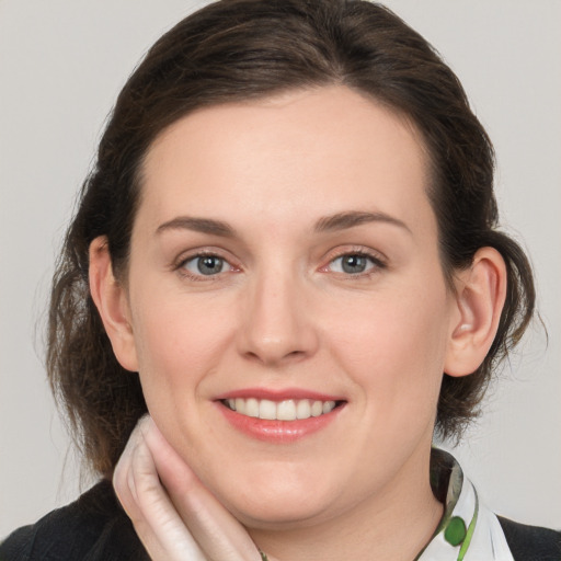 Joyful white young-adult female with medium  brown hair and green eyes