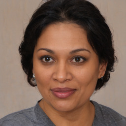 Joyful black adult female with medium  brown hair and brown eyes