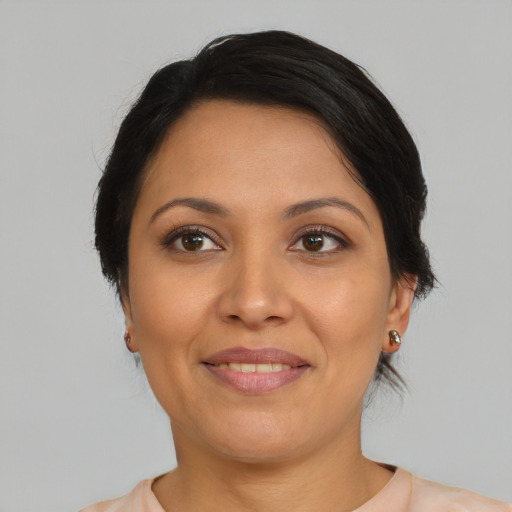 Joyful latino adult female with medium  brown hair and brown eyes