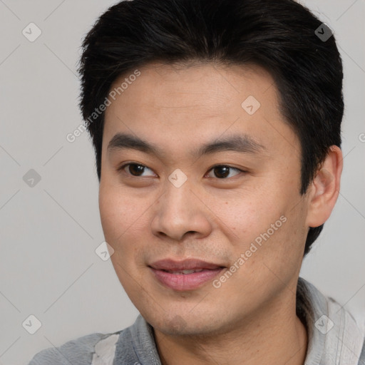 Joyful asian young-adult male with short  brown hair and brown eyes