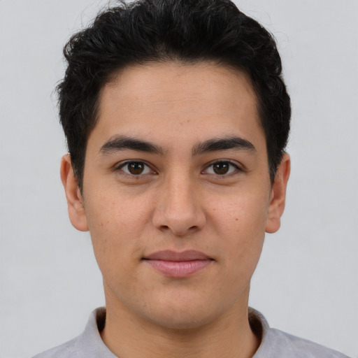 Joyful latino young-adult male with short  brown hair and brown eyes