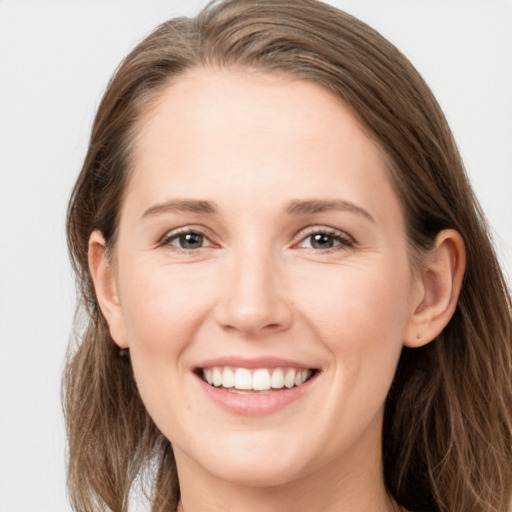 Joyful white young-adult female with long  brown hair and grey eyes