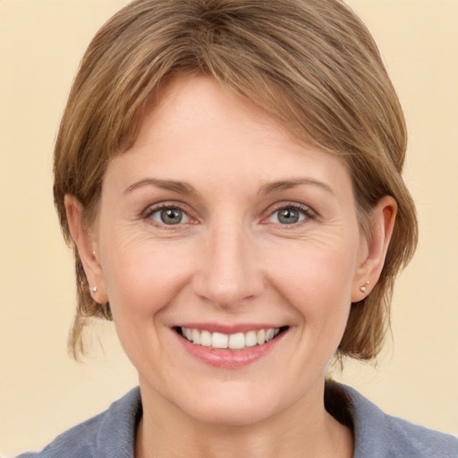 Joyful white young-adult female with medium  brown hair and grey eyes