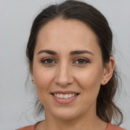 Joyful white adult female with long  brown hair and brown eyes