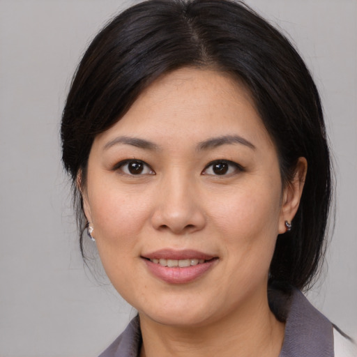 Joyful asian adult female with medium  brown hair and brown eyes