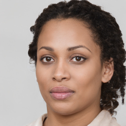 Joyful black young-adult female with medium  brown hair and brown eyes