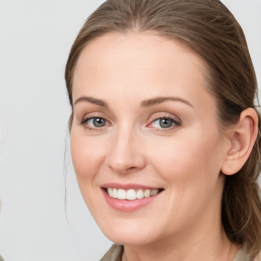 Joyful white young-adult female with long  brown hair and blue eyes