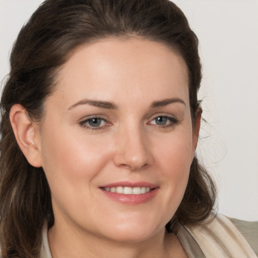 Joyful white young-adult female with long  brown hair and brown eyes