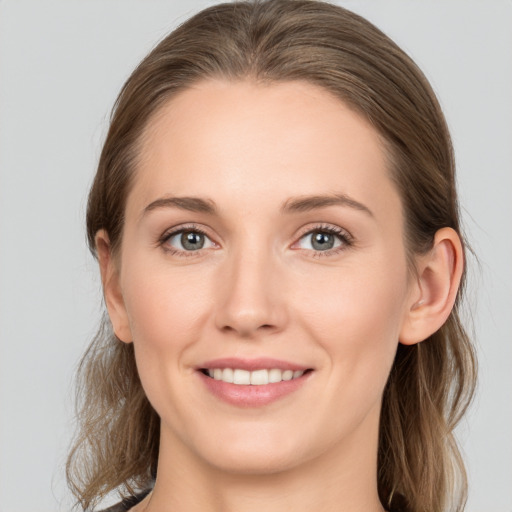 Joyful white young-adult female with long  brown hair and grey eyes