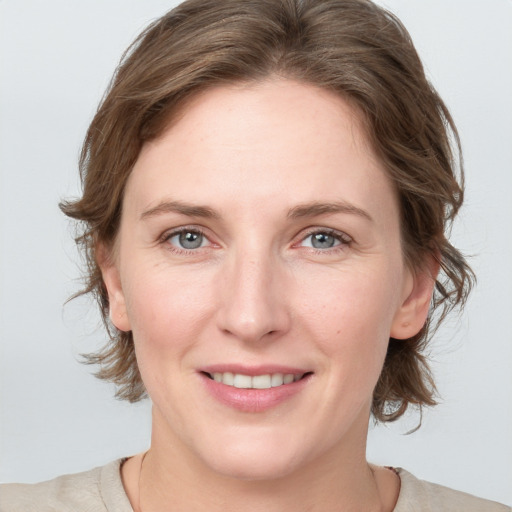 Joyful white adult female with medium  brown hair and grey eyes