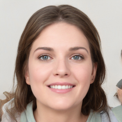 Joyful white young-adult female with medium  brown hair and grey eyes