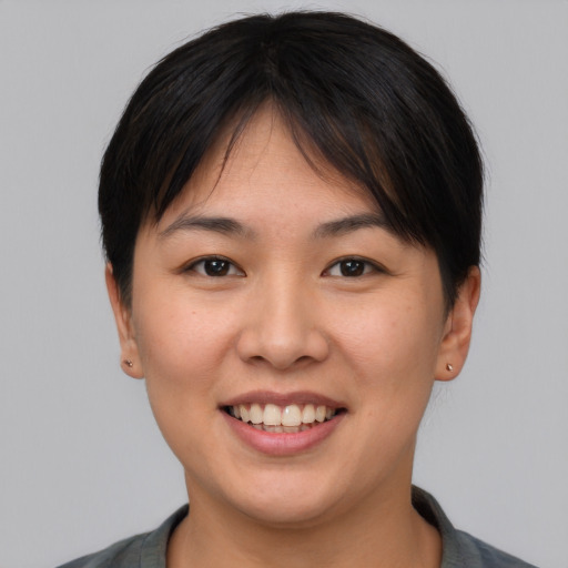 Joyful asian young-adult female with short  brown hair and brown eyes