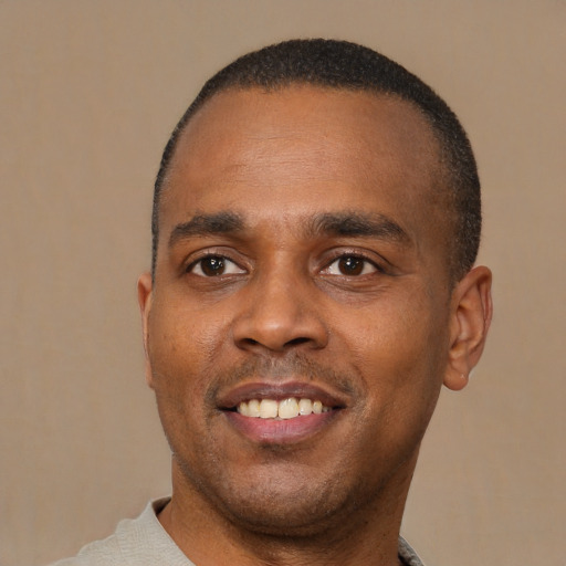 Joyful latino young-adult male with short  brown hair and brown eyes