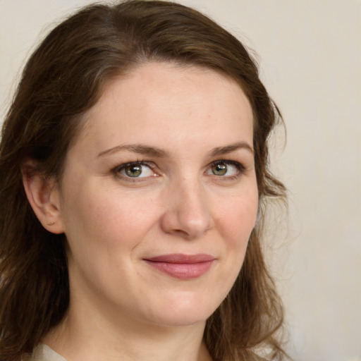 Joyful white young-adult female with long  brown hair and green eyes