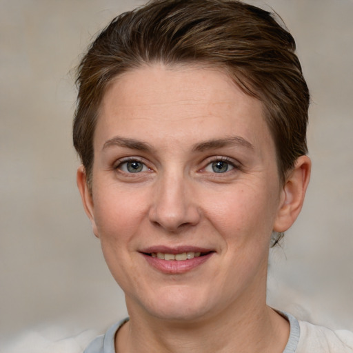 Joyful white adult female with short  brown hair and grey eyes