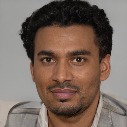 Joyful black young-adult male with short  black hair and brown eyes