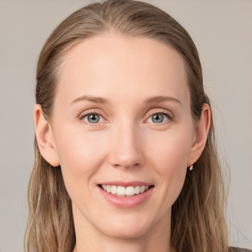 Joyful white young-adult female with long  brown hair and blue eyes