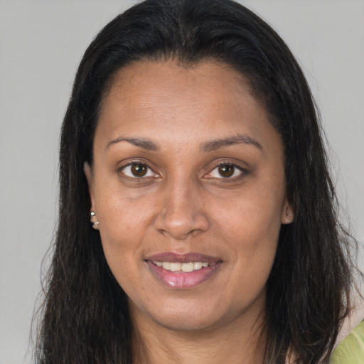 Joyful latino adult female with long  brown hair and brown eyes