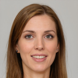 Joyful white young-adult female with long  brown hair and green eyes