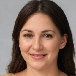 Joyful white young-adult female with long  brown hair and brown eyes