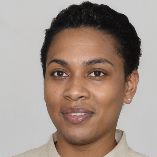 Joyful black young-adult female with short  black hair and brown eyes
